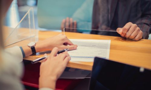 Cliente assinando recibo de uma remessa no balcao de uma loja